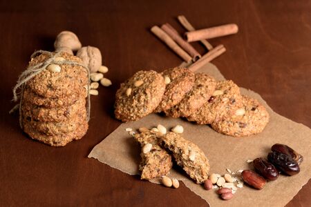 homemade oatmeal cookies with dates, peanuts, coconut shavings on a wooden background, macro close-up. broken cookies in the foreground. space for text.の写真素材