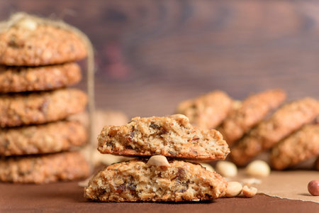 homemade oatmeal cookies with dates, peanuts, coconut shavings on a wooden background, macro...