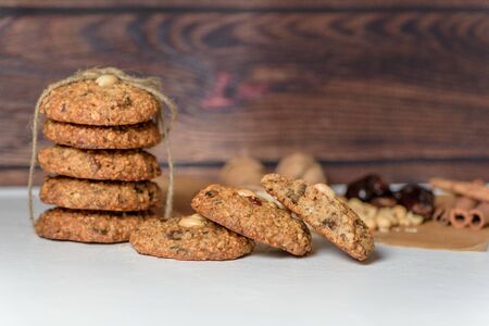 homemade oatmeal cookies with dates, peanuts, coconut shavings on a wooden background, macro close-up. broken cookies in the foreground. space for text.の写真素材