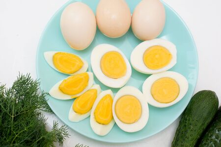 ingredients for a recipe of homemade Russian national cold okroshka soup on a light background. potatoes, radishes, sausage, onions, herbs, eggs. top view close-up.の写真素材