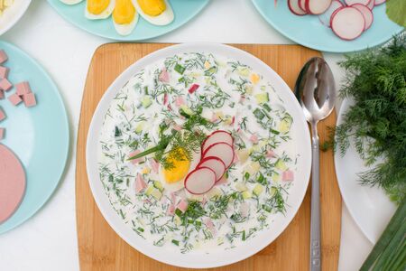 recipe of Russian national cold okroshka soup in a white plate on a light background. top view on a light background.の写真素材
