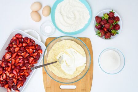 step by step recipe strawberry cobbler homemade from ripe fresh strawberries and shortbread on a light background, top view. ingredients for strawberry pie. knead the shortbread dough.の写真素材