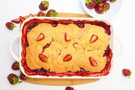 homemade strawberry cobbler made from ripe fresh strawberries. cut strawberry pie on a blue plate on a light background.の写真素材