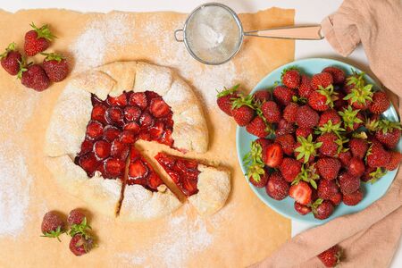 homemade strawberry Biscuit with fresh ripe strawberries on parchment on a light background, top view.の写真素材