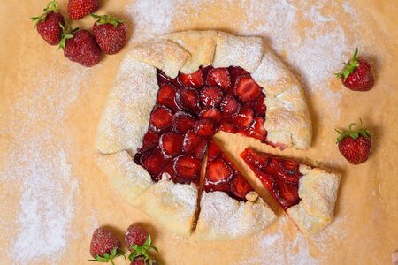 homemade strawberry Biscuit with fresh ripe strawberries on parchment on a light background, top view.の写真素材