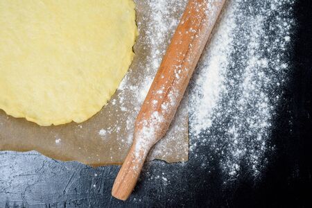 rolling pin for dough with flour scattered on a dark background. top view, close-up, space for text . preparation for making dough at home.の写真素材