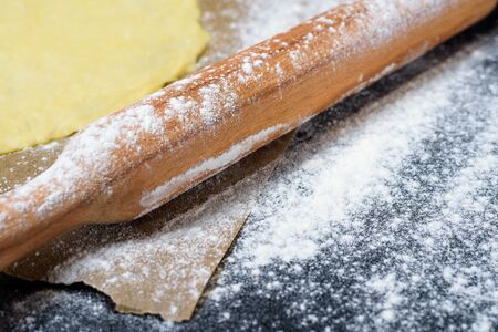 rolling pin for dough with flour scattered on a dark background. top view, close-up, space for text . preparation for making dough at home.の写真素材