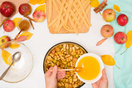 Autumn baking concept. step-by-step recipe for baking a traditional autumn Apple pie, copy the space on a light background. knead the dough and pour the apples into the dough.の写真素材