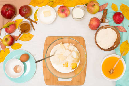 ingredients and recipe for homemade Apple cupcakes and muffins, top view light background, yellow leaves. the concept of fall baking and fall harvest. mixing flour, eggs and butter, knead the dough.の写真素材