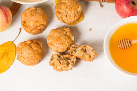 homemade Apple cupcakes and muffins, light background, yellow leaves. the concept of fall baking and...
