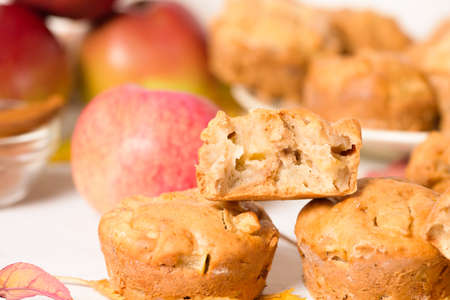 homemade Apple cupcakes and muffins, light background, yellow leaves. the concept of fall baking and fall harvest. the cupcake is broken into pieces, filling with Apple. close up.の写真素材
