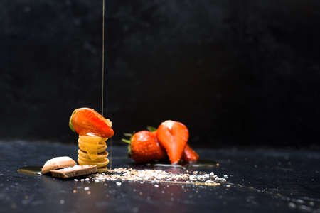 mini pancake cereal bowl with fresh strawberries banana chocolate, coconut shavings and honey in small plates. the view from the top. the trend of self-isolation.の写真素材