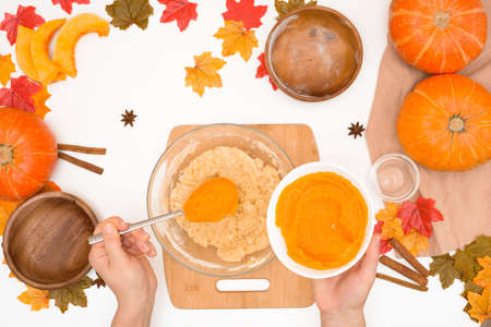 recipe and ingredients for cooking autumn pumpkin cupcakes. top view on a light background. the process of mixing flour, butter, eggs, sugar and pumpkin in a plate.の写真素材