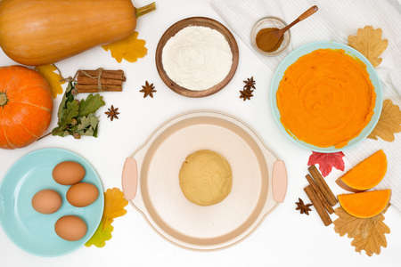 step-by-step recipe for cooking homemade pumpkin pie with spices ingredients on plates top view on a light backgroundの写真素材