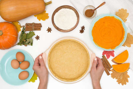 step-by-step recipe for cooking homemade pumpkin pie with spices ingredients on plates top view on a light background. forming a cake in a baking dish.の写真素材