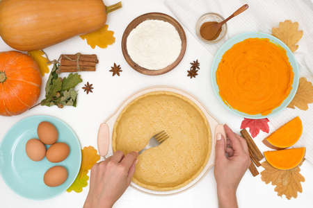 step-by-step recipe for cooking homemade pumpkin pie with spices ingredients on plates top view on a light background. forming a cake in a baking dish.の写真素材