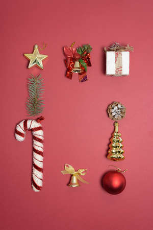 Christmas composition of Christmas toys, candy and spruce branches on a red background. template for postcards. new yearの写真素材