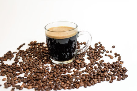 a Cup of fresh coffee stands on coffee beans on a white background. space for text. background image