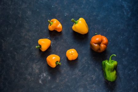 spiral of orange pepper on a dark background. composition, background image. top view