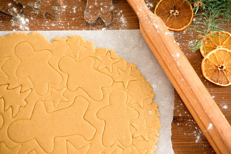 cut gingerbread out of the dough using a gingerbread mold, top view, raw dough with cinnamon...