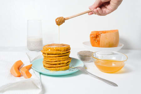 a stack of autumn pumpkin pancakes with Chia seeds and honey on a light background. delicious healthy vegetarian diet Breakfast. the concept of taking care of your body, the keto dietの写真素材