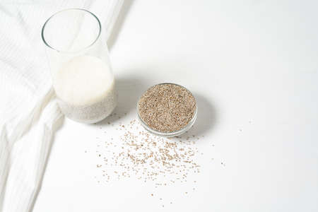 steeped in a glass of white Chia seeds on a light background, dry Chia in a glass plate, vegetarian healthy food with omega and vitamins. superfood for weight loss and self-care.の写真素材