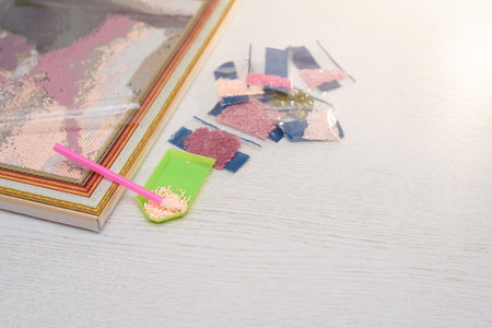 home hobby to draw a picture of rhinestones, multicolored diamond mosaic. the process of gluing a pencil of rhinestones on the canvas of the picture.の写真素材
