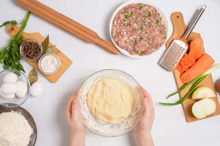 the process of cooking Uzbek manti at home, the ingredients are meat, vegetables, dough. top view on a light background.の写真素材