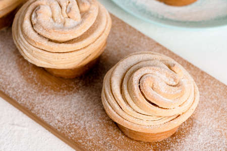 cruffins easter spring pastries, muffin and croissant roll on a light background, close-up for text place. fresh homemade festive kulich.の写真素材
