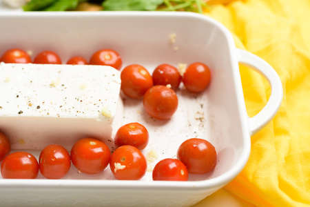 step-by-step preparation and ingredients for oven-baked feta cheese with tomatoes and pasta, pepper garlic on a light background top view, trend recipe, mixing macaroni and cheese.の写真素材