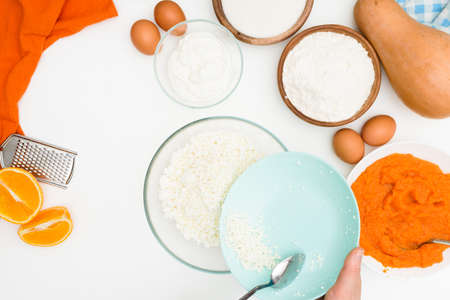 step-by-step recipe for pumpkin curd casserole in the shape of a zebra, orange autumn pie with orange. mixing ingredients for pumpkin pie top view. add flour and sugar to the dough.の写真素材