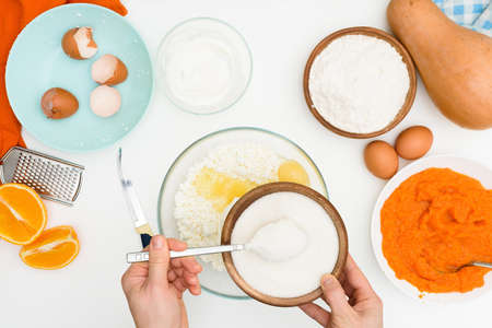 step-by-step recipe for pumpkin curd casserole in the shape of a zebra, orange autumn pie with orange. mixing ingredients for pumpkin pie top view. add flour and sugar to the dough.の写真素材
