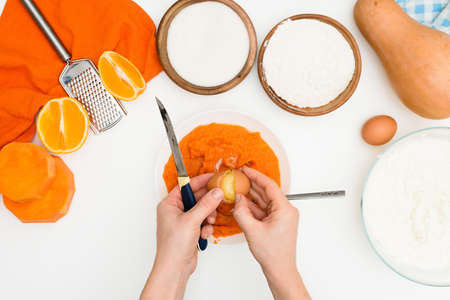 step-by-step recipe for pumpkin curd casserole in the shape of a zebra, orange autumn pie with orange. mixing ingredients for pumpkin pie top view. add flour and sugar to the dough.の写真素材