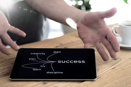 Man holding a tablet PC with both hands on the sides. The screen surface is displayed successfully.の写真素材