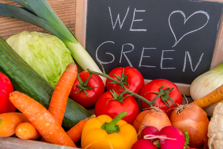 Various vegetables in a box. We love green, standing on a blackboard in the background.の写真素材