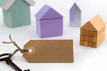 Blank label on a key, model houses in the background.の写真素材