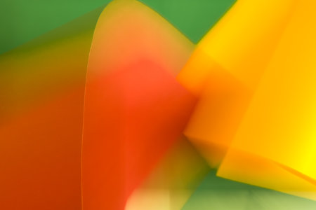 Blurred orange and yellow shapes on green background.の写真素材