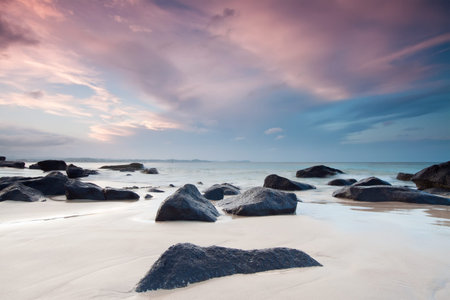 australian beach at twilight with interesting rocky foregroundの写真素材