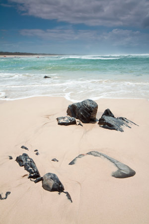 australian beach during the day with rocks in foreground