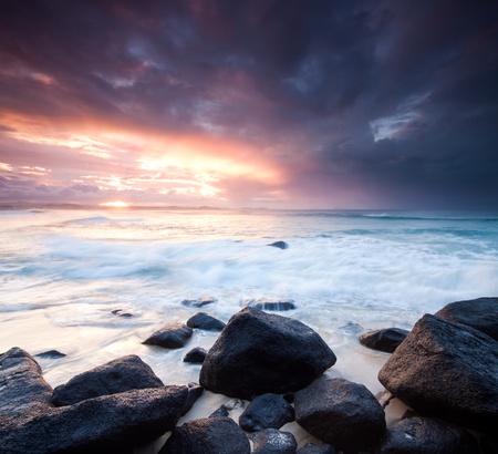 australian seascape during the twilight with rocks in foreground (rainbow bay beach,tweed heads,nsw)の写真素材