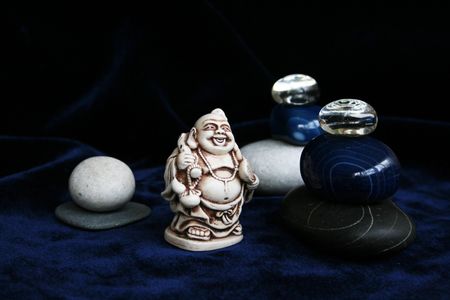 White, black and blue pebble, two glass spheres and Buddha figurine in Zen compositionの写真素材