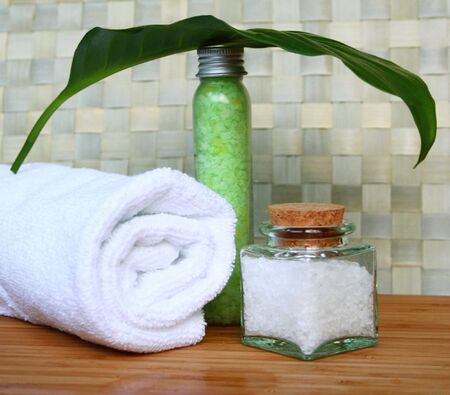 White bath towel, bottles of sea salt in spa compositionの写真素材