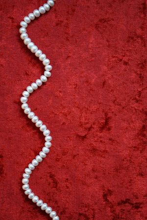 Necklace of white pearls on a terracotta velvet as background の写真素材