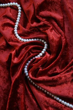 Necklace of white pearls on a terracotta velvet as background の写真素材