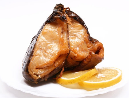 Smoke-cured catfish with lemon on white plate