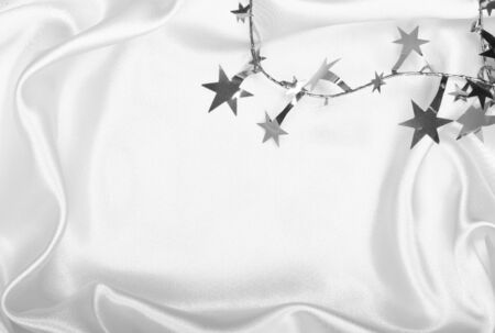 Silver stars and spangles on white silk can use as backgroundの写真素材