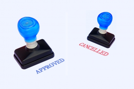 Rubber stamper with the word APPROVED and CANCELLED printed in redの写真素材