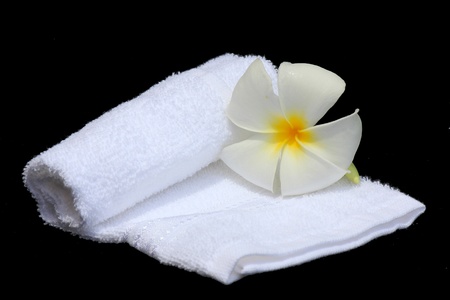 White Frangipani flower and towel Isolated on black backgroundの写真素材