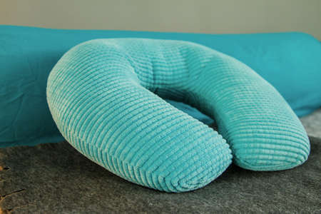 Turquoise orthopedic bright soft travel neck pillow on the bedの写真素材