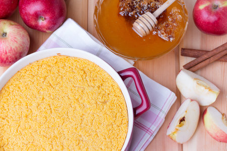 couscous casserole kodafa with apples, honey and cinnamon on wooden background